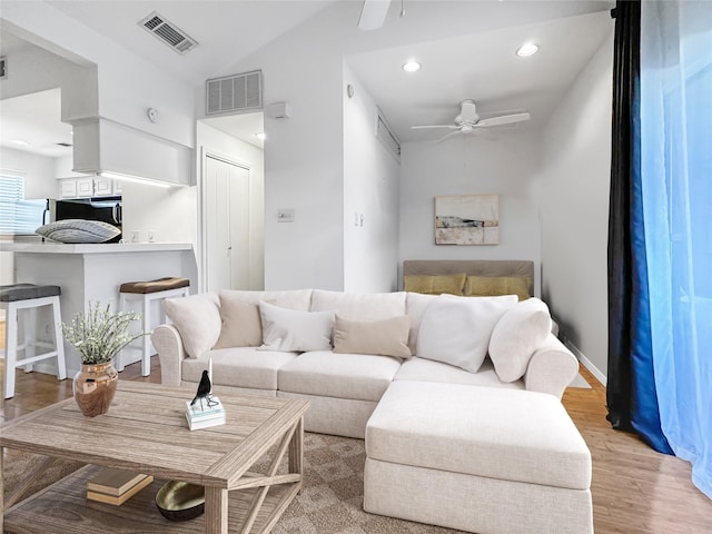 living room with light hardwood / wood-style floors and ceiling fan