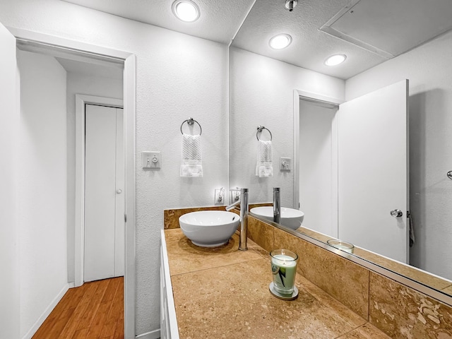 bathroom featuring vanity, hardwood / wood-style flooring, and a textured ceiling