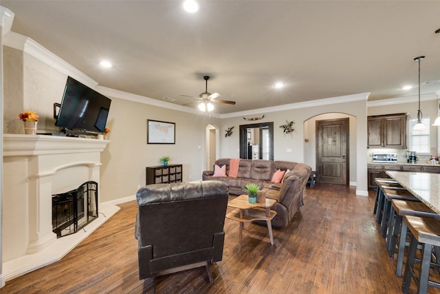 living room with ceiling fan, ornamental molding, and dark hardwood / wood-style flooring