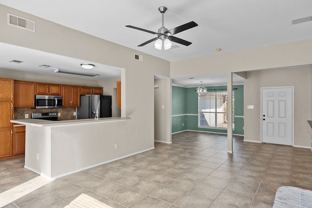 kitchen with ceiling fan with notable chandelier, tasteful backsplash, and stainless steel appliances