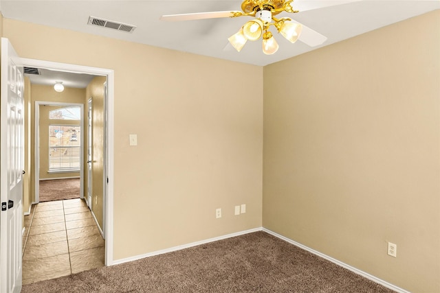 carpeted spare room featuring ceiling fan