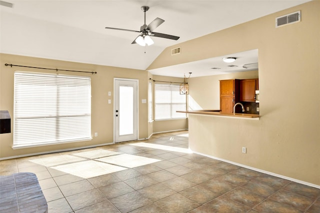 unfurnished living room with tile patterned flooring, sink, vaulted ceiling, and ceiling fan