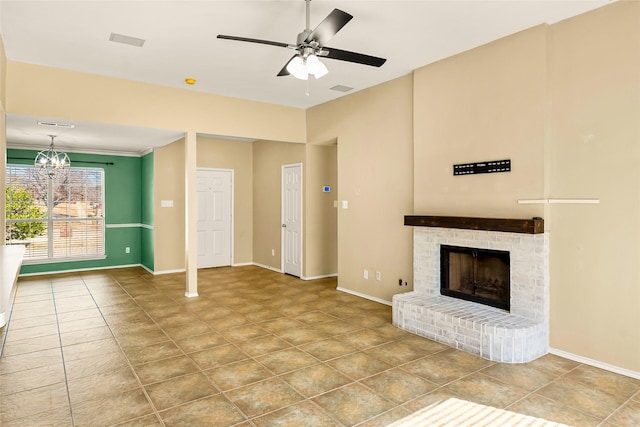 unfurnished living room with tile patterned flooring, ceiling fan with notable chandelier, and a fireplace