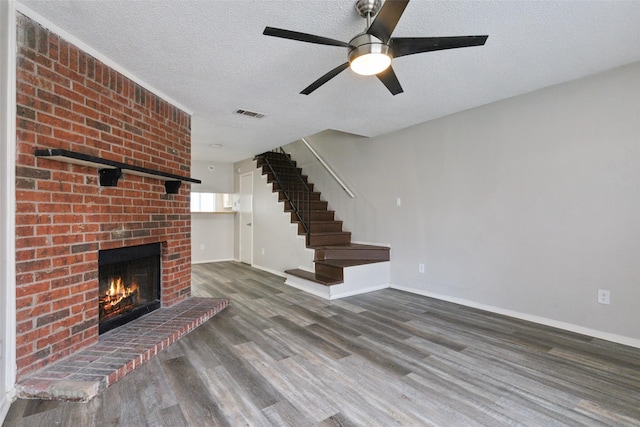 unfurnished living room with a fireplace, dark wood-type flooring, and a textured ceiling