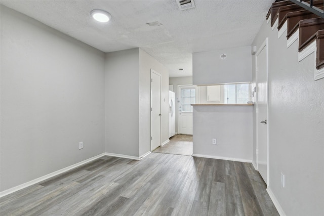 spare room with hardwood / wood-style flooring and a textured ceiling