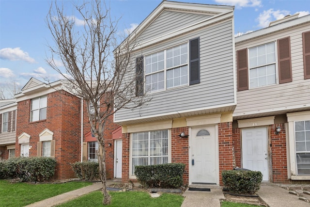 townhome / multi-family property featuring a front lawn