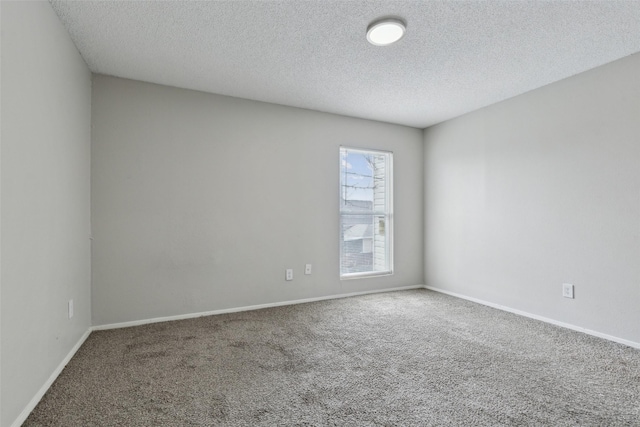 spare room with a textured ceiling and carpet floors