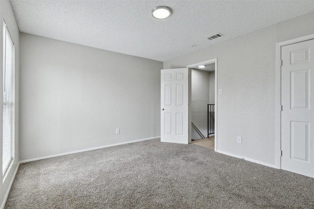 interior space with light carpet and a textured ceiling