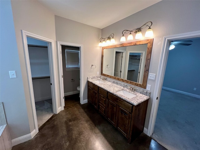 bathroom featuring toilet, vanity, and concrete flooring