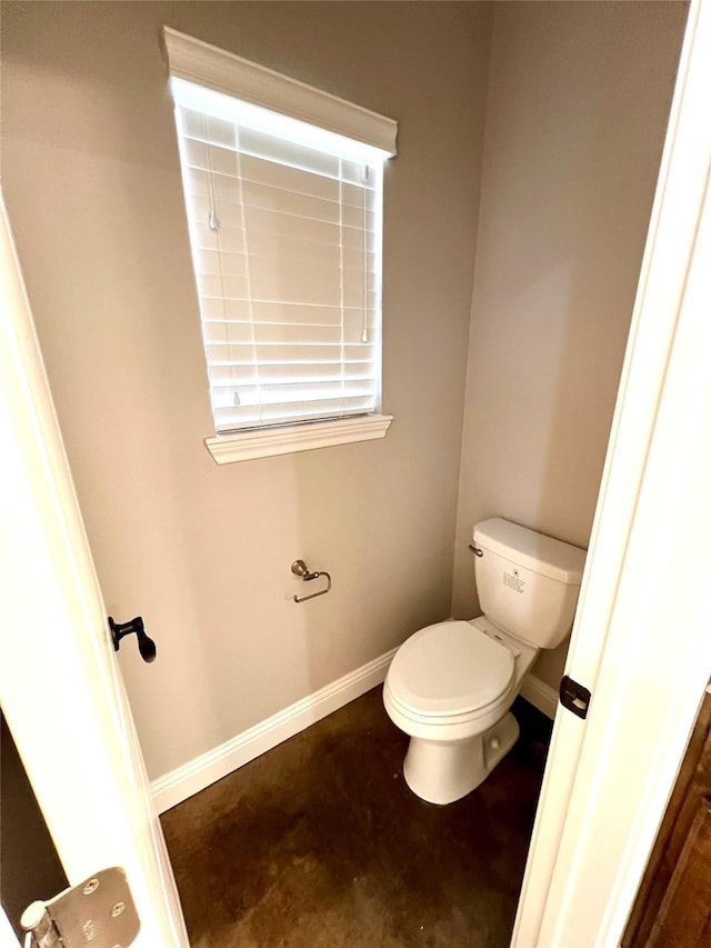 bathroom with toilet and concrete flooring