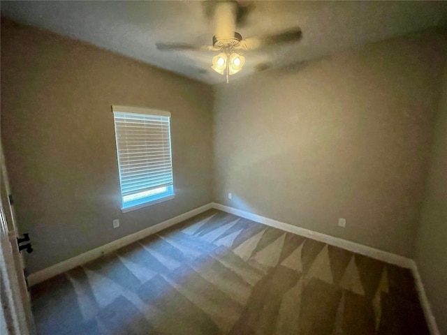 carpeted spare room featuring ceiling fan