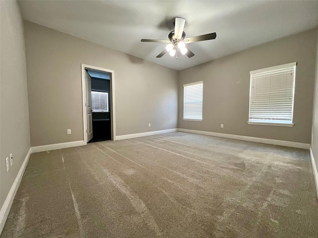 empty room with ceiling fan and carpet flooring