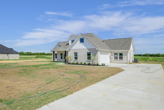 view of front of property featuring cooling unit, a garage, and a front yard