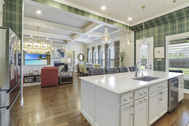 kitchen featuring sink, pendant lighting, a kitchen island with sink, and white cabinetry