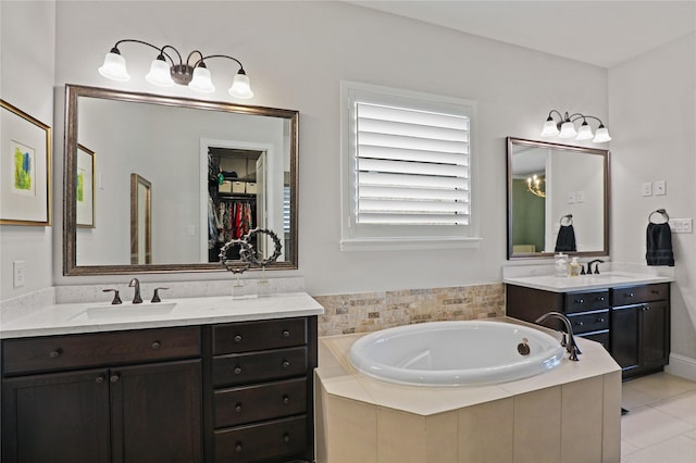 bathroom featuring tiled bath, tile patterned floors, and vanity