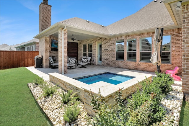 view of pool featuring a jacuzzi, a patio area, a lawn, and ceiling fan