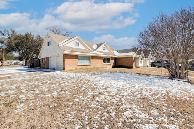 snow covered property featuring a garage