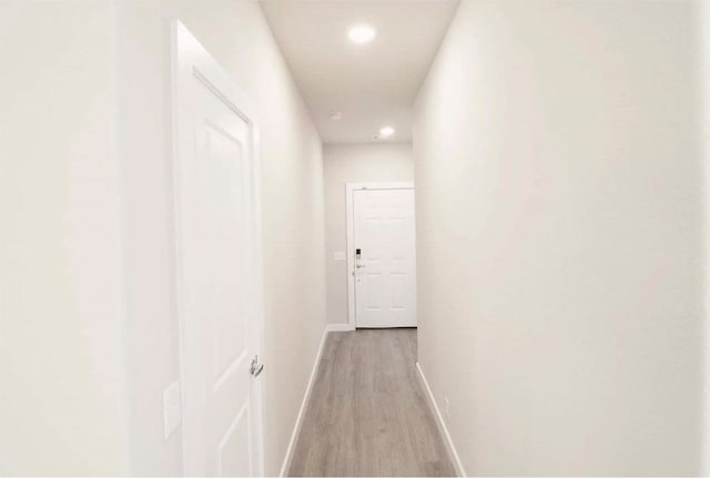 corridor with light hardwood / wood-style floors