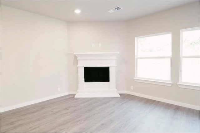 unfurnished living room with a healthy amount of sunlight and light wood-type flooring