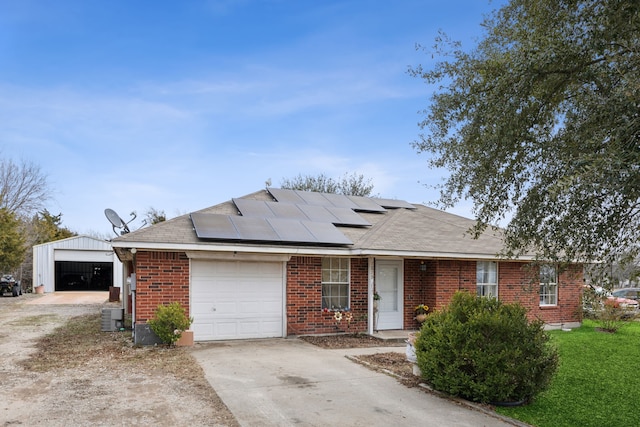 ranch-style house with a garage, solar panels, and central air condition unit