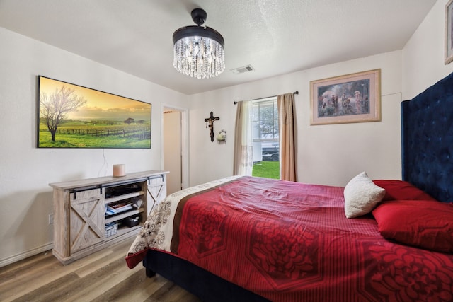 bedroom featuring hardwood / wood-style flooring and a notable chandelier