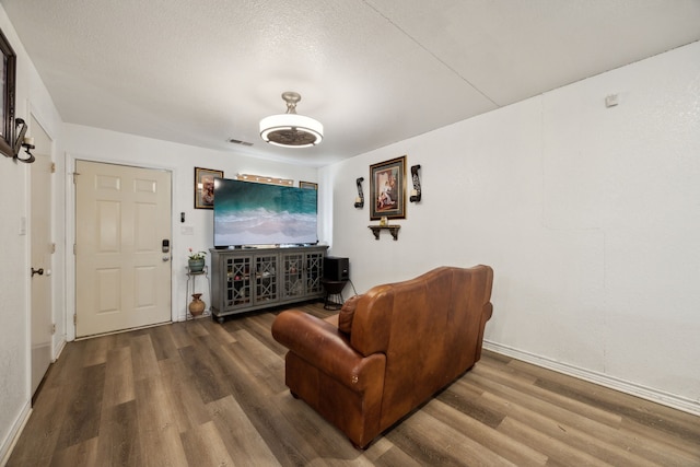 living room with hardwood / wood-style floors and a textured ceiling