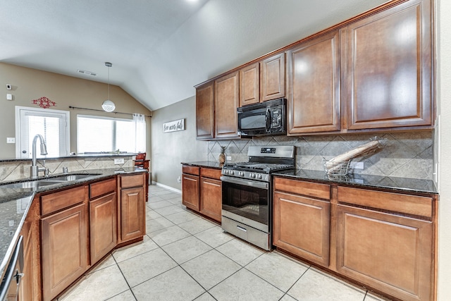 kitchen with vaulted ceiling, dark stone counters, sink, pendant lighting, and stainless steel appliances