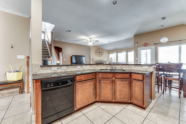 kitchen with dishwasher, hanging light fixtures, light tile patterned floors, sink, and backsplash