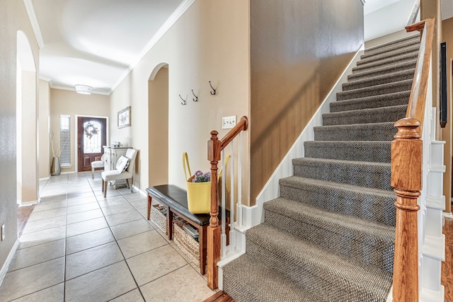 staircase with tile patterned flooring and ornamental molding