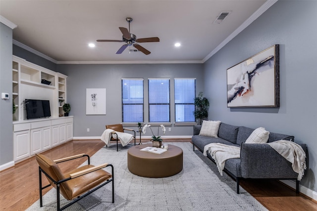 living room with ceiling fan, ornamental molding, and wood-type flooring