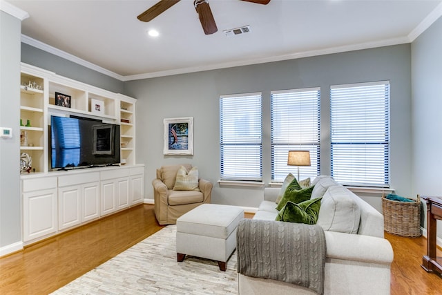 living room with hardwood / wood-style flooring, ornamental molding, and ceiling fan