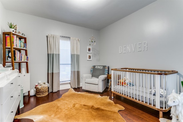 bedroom featuring a crib and hardwood / wood-style flooring