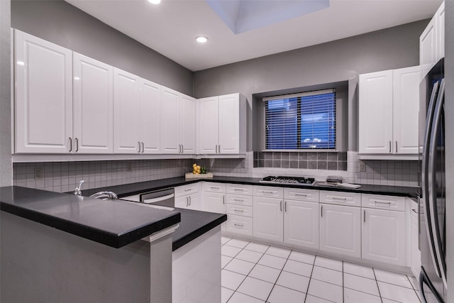 kitchen featuring kitchen peninsula, white cabinetry, and appliances with stainless steel finishes