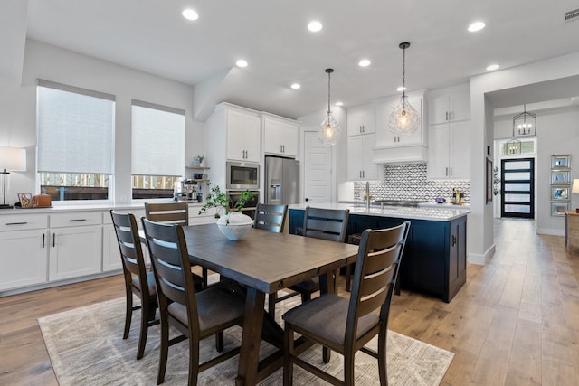 dining area with light wood-style floors, recessed lighting, visible vents, and baseboards