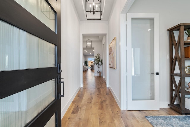 entrance foyer with a notable chandelier and light wood-type flooring