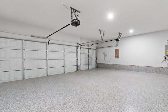 garage featuring a garage door opener, recessed lighting, and electric panel