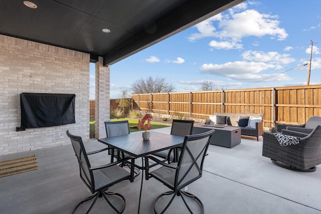 view of patio featuring an outdoor living space with a fire pit, a fenced backyard, and outdoor dining space