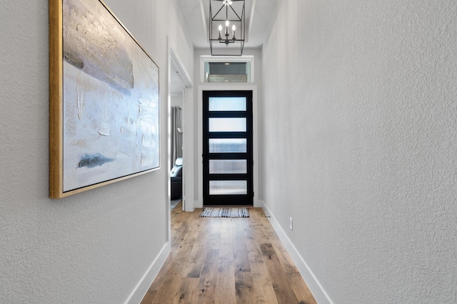 entryway featuring hardwood / wood-style flooring and a chandelier