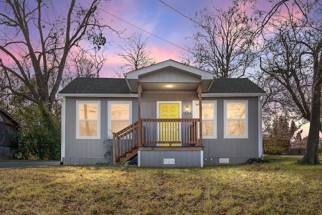 view of front of property with crawl space, a shingled roof, and a front yard