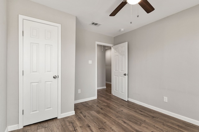 unfurnished bedroom with a ceiling fan, dark wood finished floors, visible vents, and baseboards