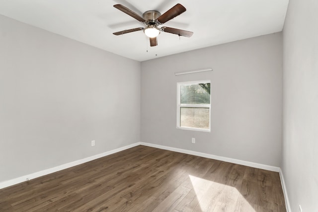 unfurnished room with wood finished floors, a ceiling fan, and baseboards