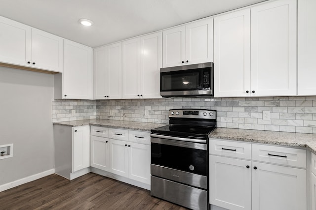 kitchen with white cabinets, decorative backsplash, dark wood-style floors, appliances with stainless steel finishes, and light stone counters