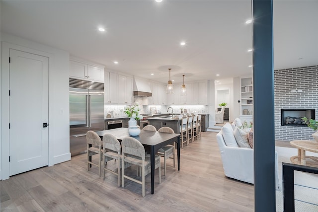 dining space featuring light hardwood / wood-style flooring and a fireplace