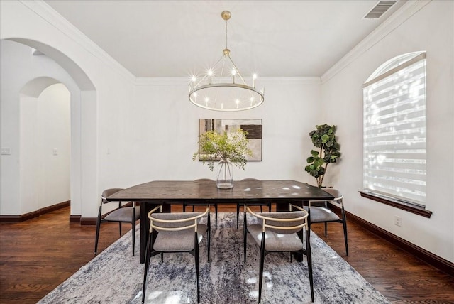 dining room featuring an inviting chandelier, ornamental molding, and dark hardwood / wood-style floors