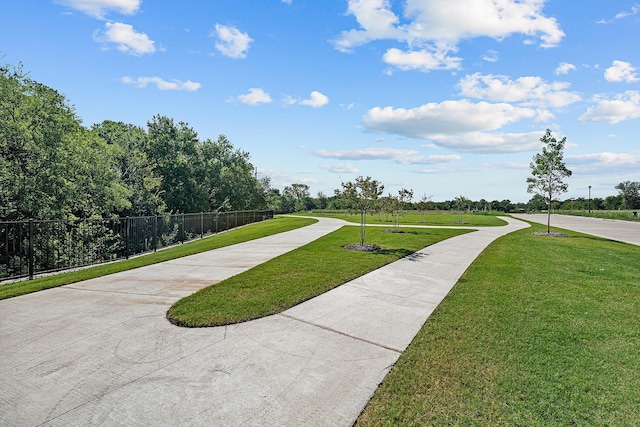 view of community with a yard and fence