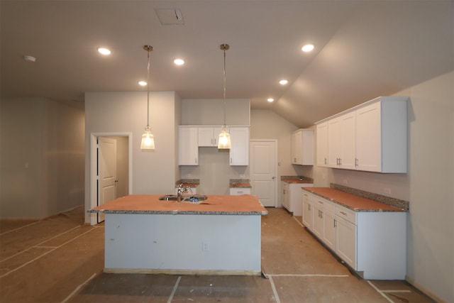 kitchen featuring recessed lighting, hanging light fixtures, white cabinetry, vaulted ceiling, and an island with sink