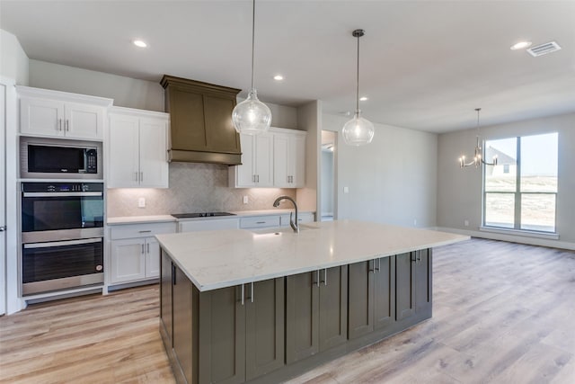 kitchen with a sink, stainless steel appliances, white cabinets, tasteful backsplash, and recessed lighting