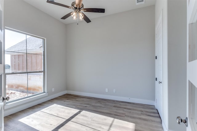 spare room with ceiling fan, baseboards, and wood finished floors