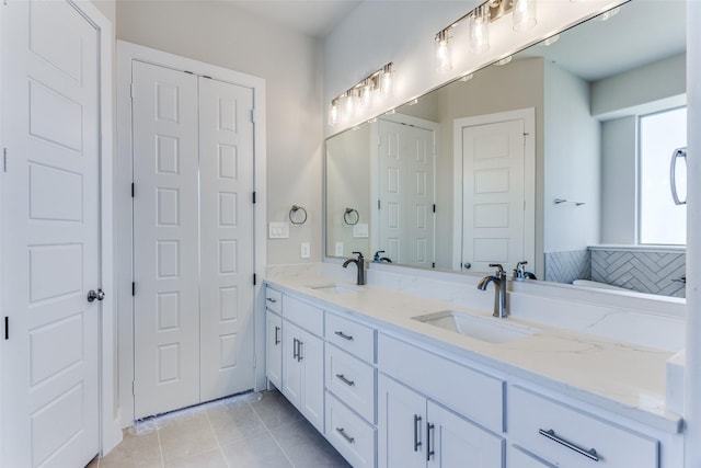 full bath featuring double vanity, tile patterned floors, and a closet