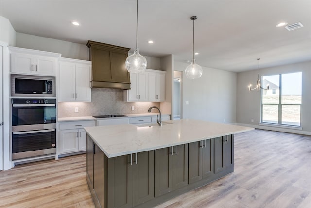 kitchen with white cabinetry, backsplash, appliances with stainless steel finishes, and a sink